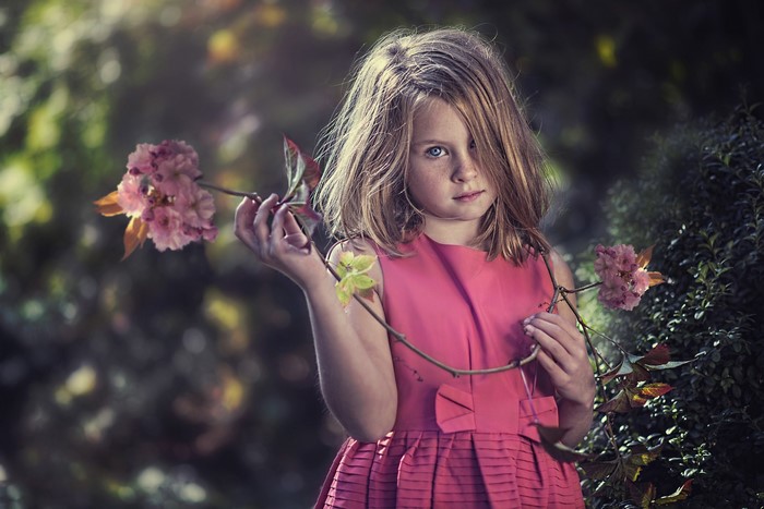 Young girl in pink dress holding flowers