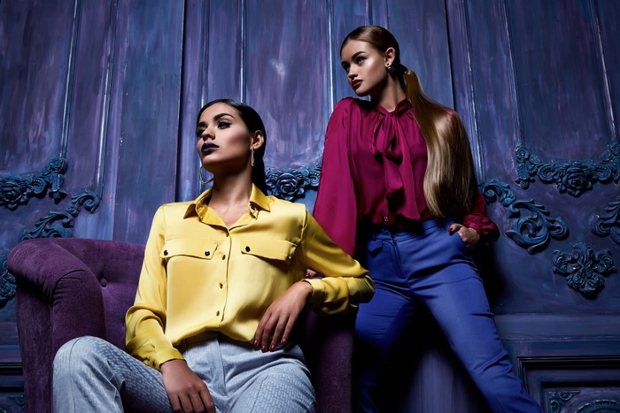 Two women posing in stylish outfits