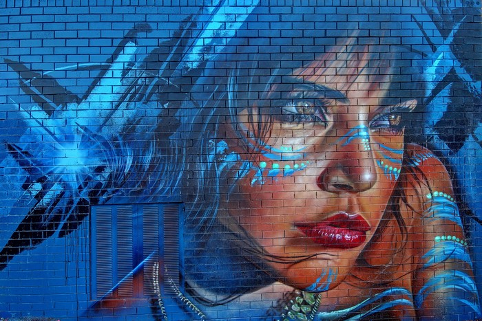 Graffiti of a woman's face on a brick wall