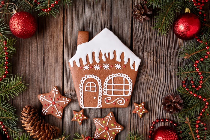 Christmas gingerbread house and cookies on wooden background