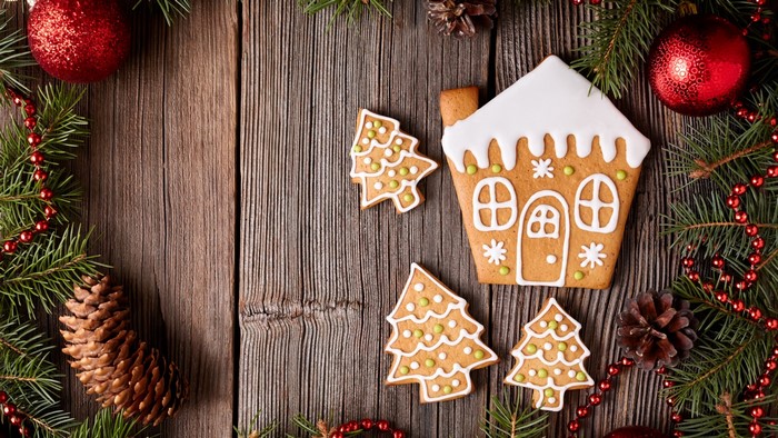 Christmas gingerbread house and cookies on wooden table