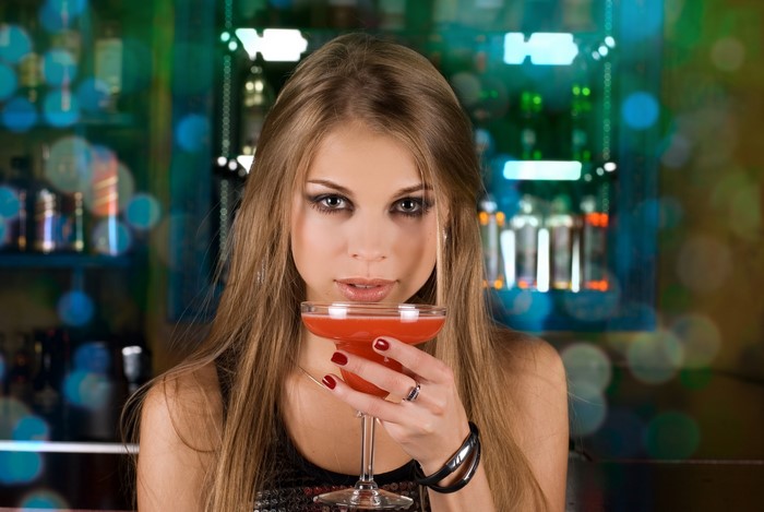 Woman holding a cocktail in a bar
