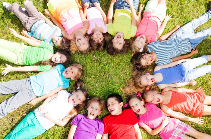 Children lying on grass singing