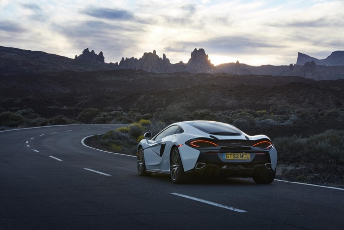 McLaren 570GT on a winding road with mountains