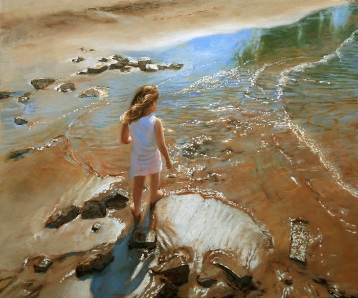 Girl in white dress on a sandy beach with rocks and waves