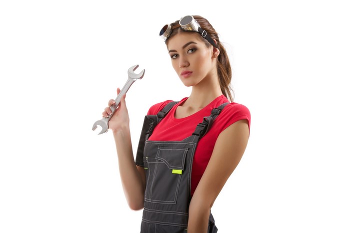 Woman in mechanic uniform holding a wrench