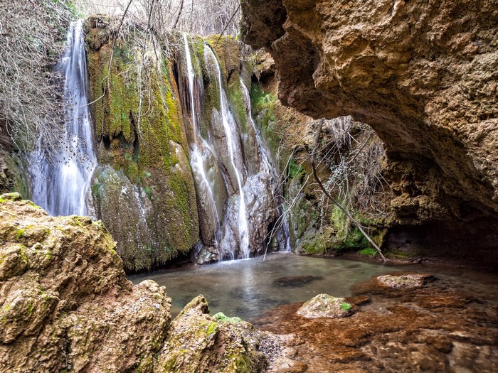Waterfall cascading over mossy rocks in Canete, Spain