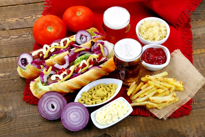 Hot dogs with beer, fries, and tomatoes
