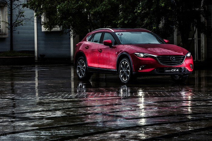 Red Mazda CX-4 parked on wet ground
