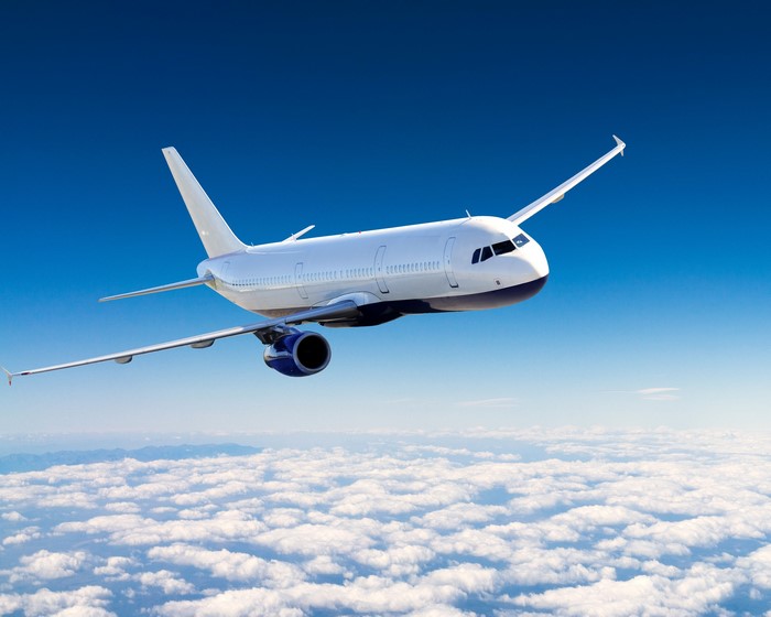 Airplane flying over clouds in a blue sky