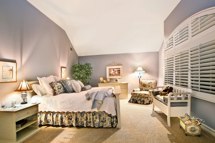 Bedroom with bed, lamps, and armchair