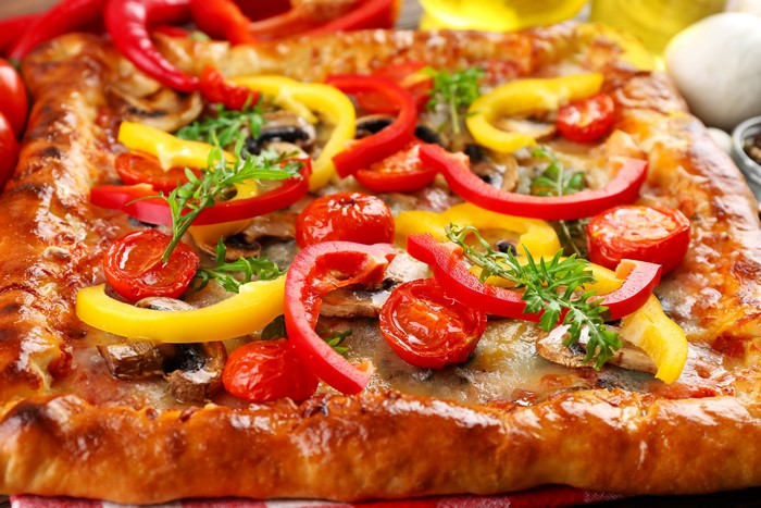 Rectangular pizza with bell peppers and tomatoes