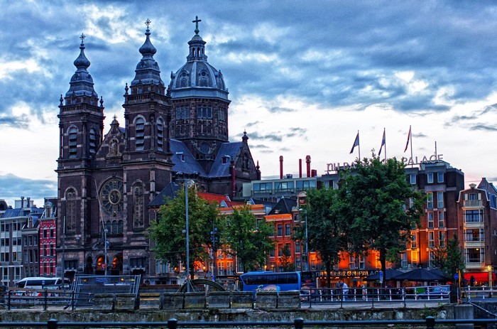 Sint Nicolaas Church and NH Barbizon Palace in Amsterdam at dusk