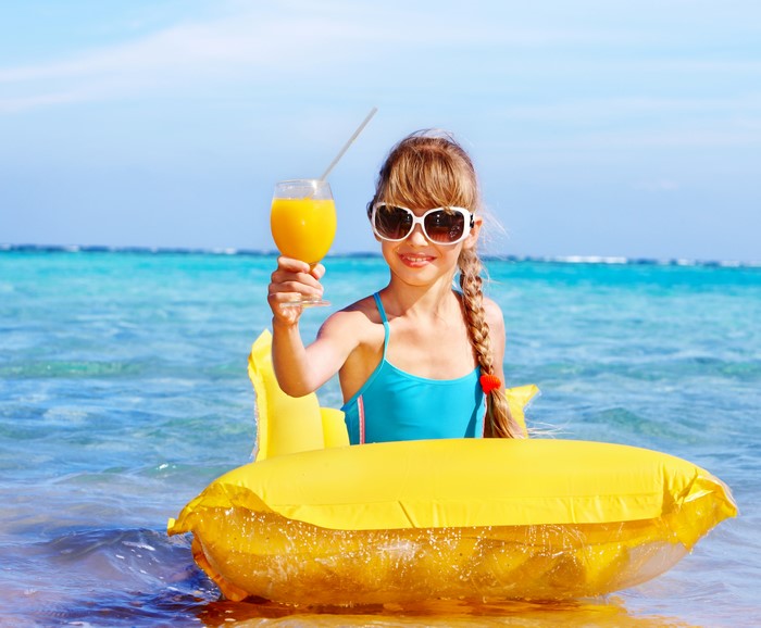 Girl with Juice on Yellow Float in Clear Sea