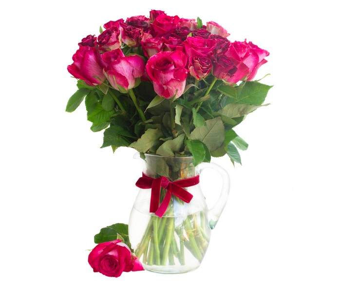 Bouquet of pink roses in a jug with a red bow