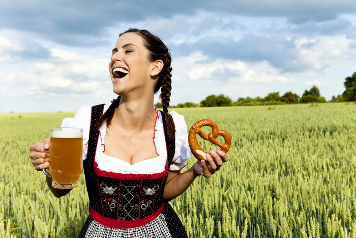 Woman in Dirndl with Beer and Pretzel in Field