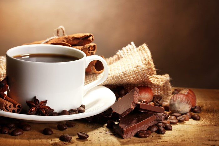 Coffee cup with chocolate, cinnamon, and nuts