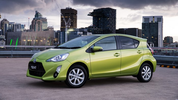 Green Toyota Prius C parked in a city
