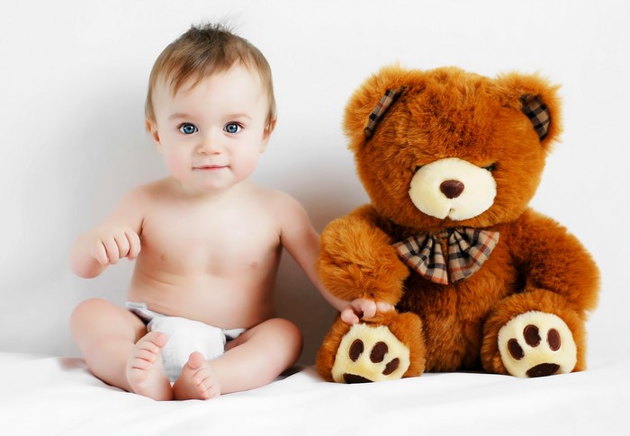 Baby sitting with a teddy bear