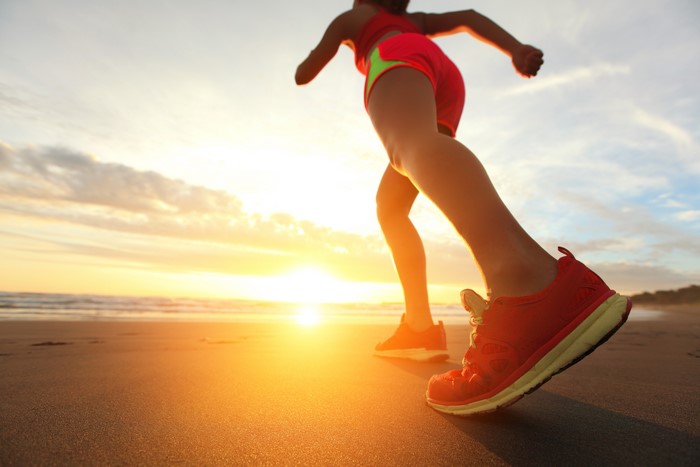 Runner on beach at sunset