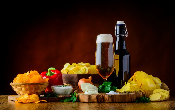 Still-life of beer, bell pepper, onion, and chips