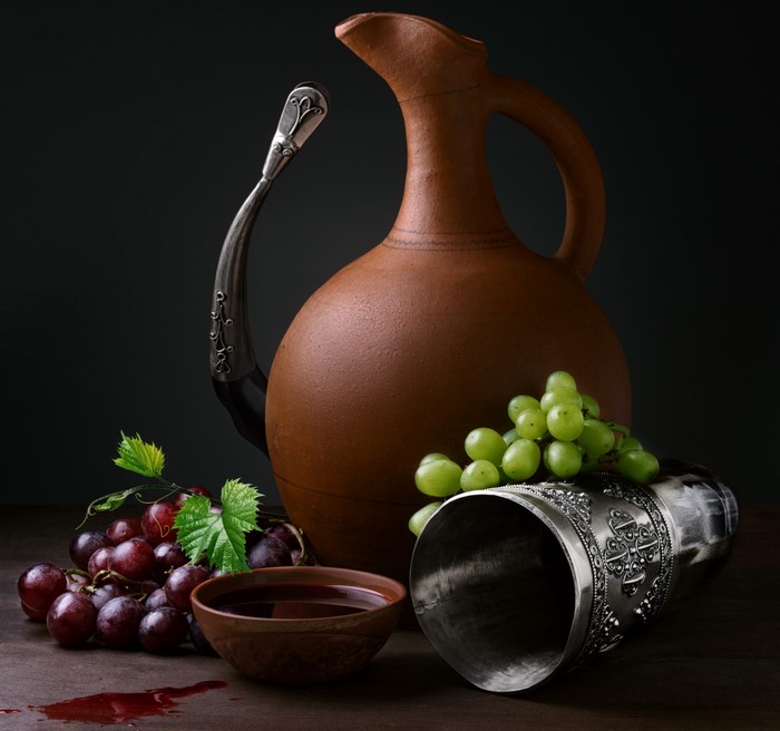 Still life with wine jug, grapes, and metal cup