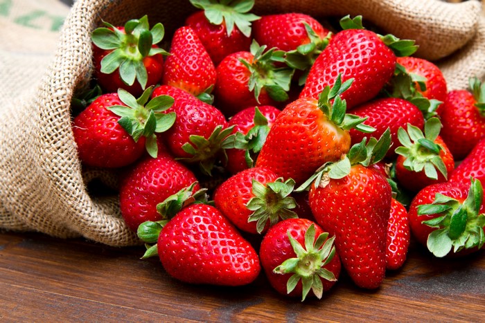 Strawberries spilling from a burlap sack