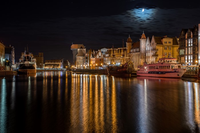 Gdańsk waterfront at night with moon and ships