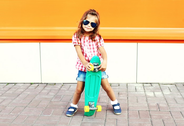 Girl with sunglasses holding a skateboard
