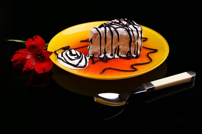 Slice of cake with chocolate drizzle and flower