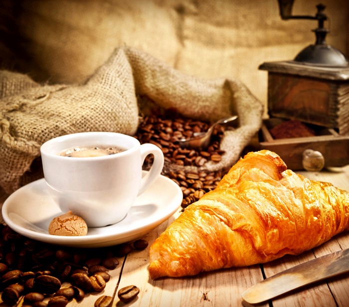 Coffee cup, croissant, and coffee beans