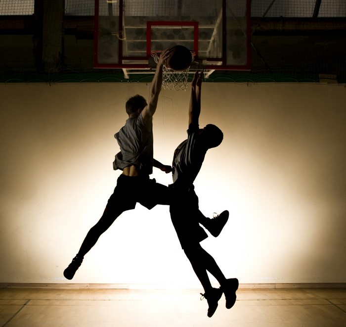 Two men playing basketball and dunking