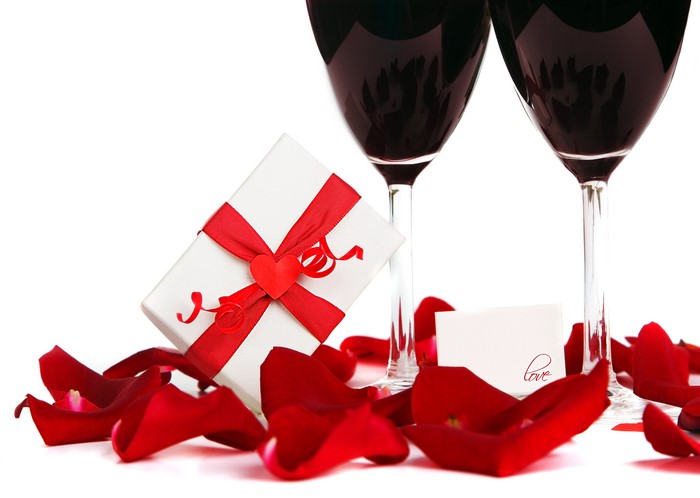 Two wine glasses, gift box, and rose petals
