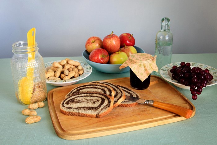 Still life with apples, grapes, nuts, bread, jam, and bottle