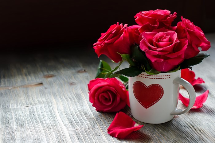 Red Roses in a Heart Mug on a Wooden Table