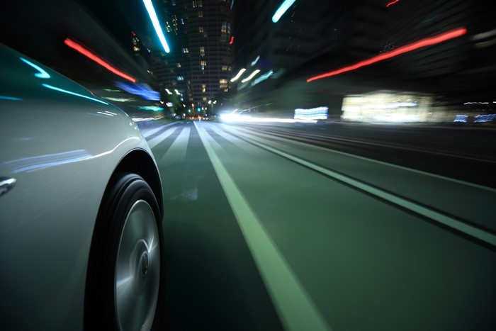 Car driving on a city road at night