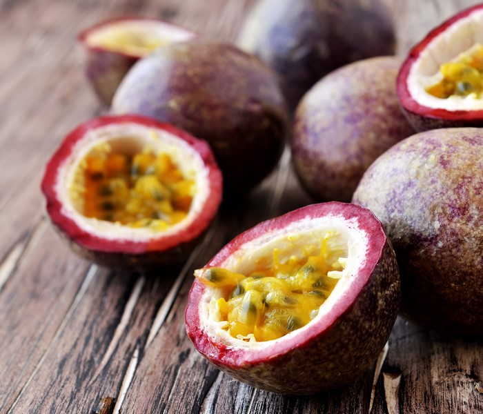Passion fruits cut in half on wooden surface