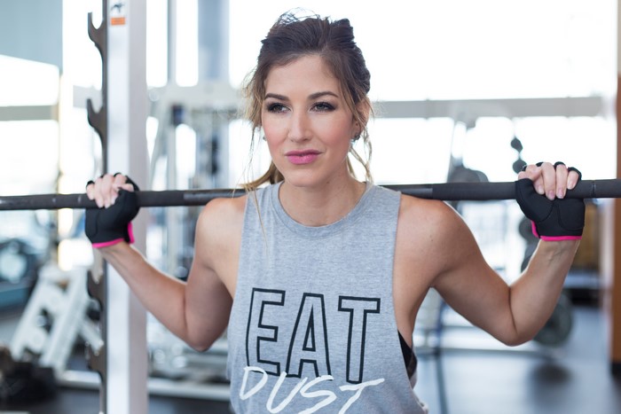 Woman in Singlet lifting Barbell