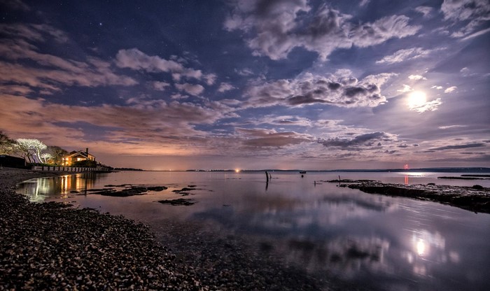 Night sky over Lymington coast with moon and clouds