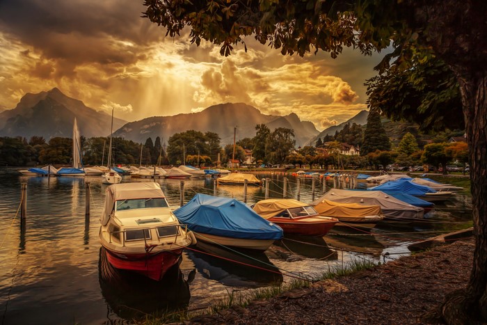 Boats docked on a lake in Switzerland at sunset