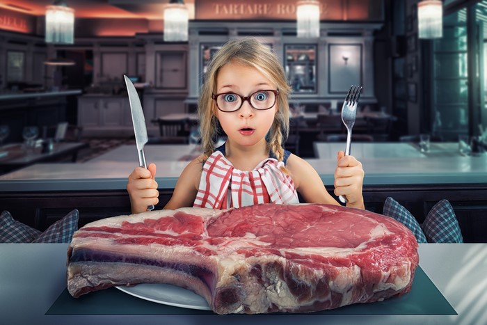 Little girl with glasses and giant meat