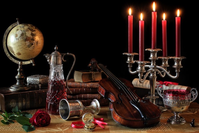Still-life with candles, violin, wine, and roses