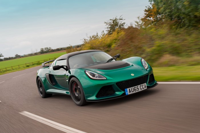 Green Lotus Exige Sport Coupe driving on a road