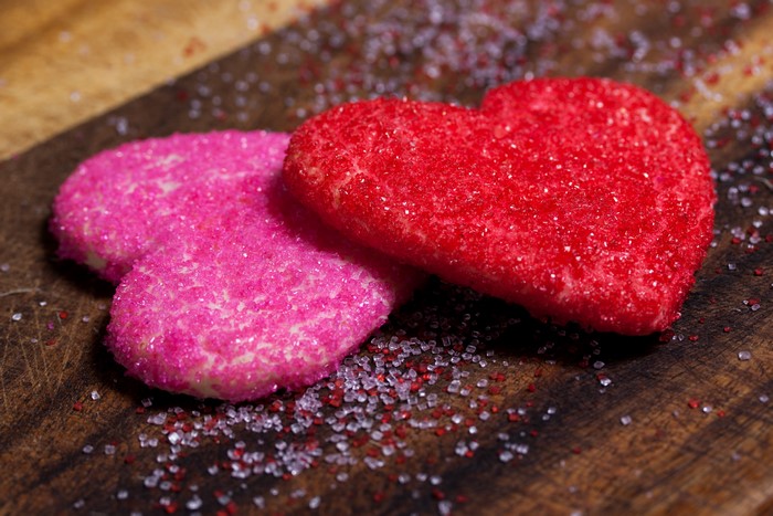 Two heart-shaped cookies with sprinkles