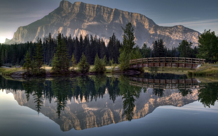 Mountain reflected in a lake with a wooden bridge