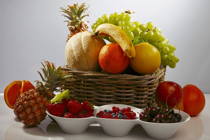 Still-life of assorted fruits in a basket and bowls