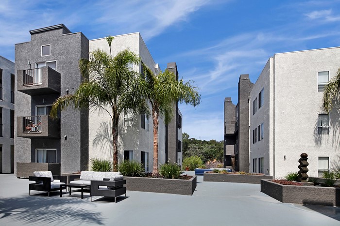 Apartment buildings with palm trees and outdoor seating