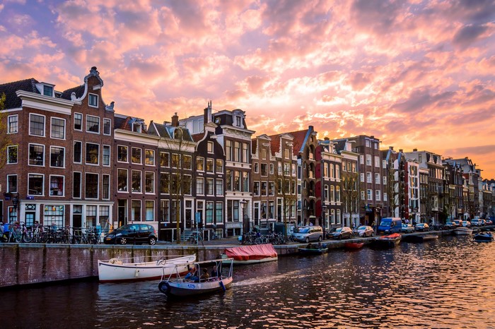 Amsterdam canal houses and boats at sunset