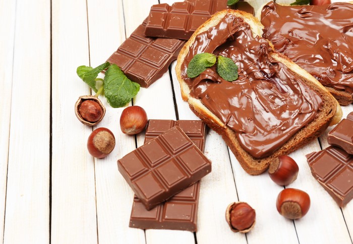 Chocolate bar, hazelnuts, and chocolate spread on toast