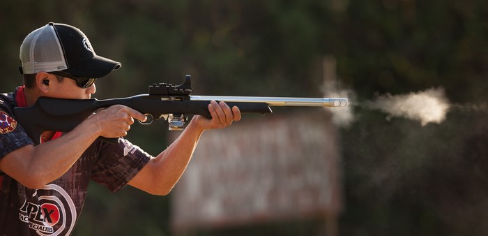 Man firing a modified rifle